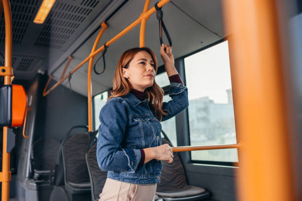 istock Young woman commuting on city bus holding strap 2187291842