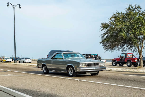 Münsingen, Germany - May 1, 2024: Chevrolet El Camino american oldtimer vintage luxury pickup truck on a country road on a sunny summer day.