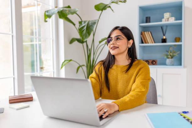 istock Bright home office setting with woman working on laptop 2187293364