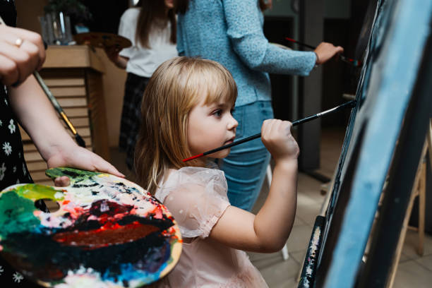 istock Girl painting on a canvas during a creative art class indoors 2187293404