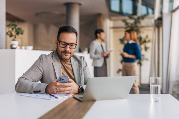 istock A businessman is texting a message while sitting at his desk 2187294247