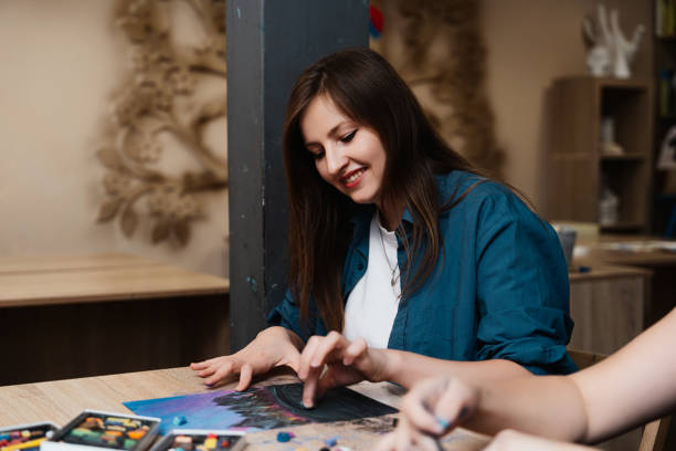 istock Woman creating artwork in a cozy studio with pastels during daytime 2187296364