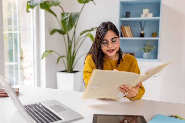 istock Engaged woman reviewing office work with open laptop 2187296415