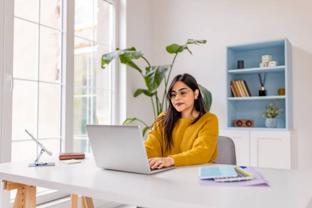 istock Engaging work scene with woman focused on laptop. 2187296554