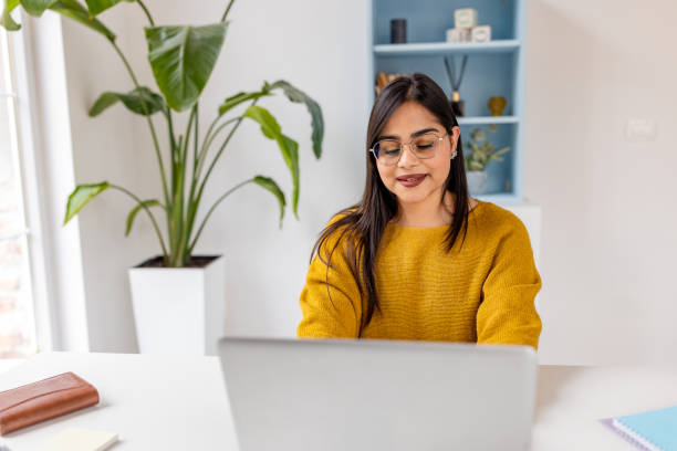 istock Modern workspace with focused woman in yellow sweater 2187300861