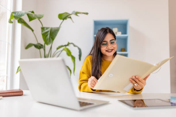 istock Smiling woman engages in document review in office. 2187301878