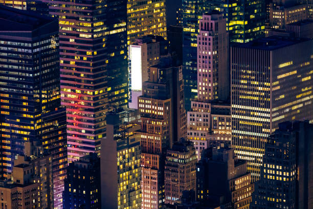 A mesmerizing view of a city skyline captured at night, showcasing the vibrant lights and architectural beauty of tall skyscrapers in a bustling urban environment.