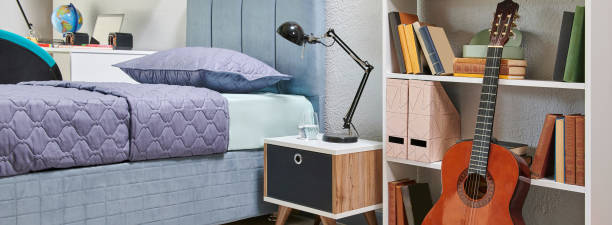 istock Teenage bedroom interior concept with bookshelf, lamp, table, book and notebook, frame, guitar, bedding set and home accessory style, architecture decoration. 2187303021