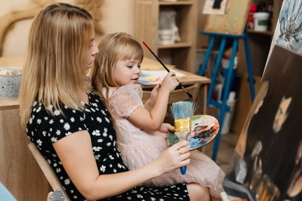 istock Mother and daughter engage in painting art lesson at a creative studio 2187303040
