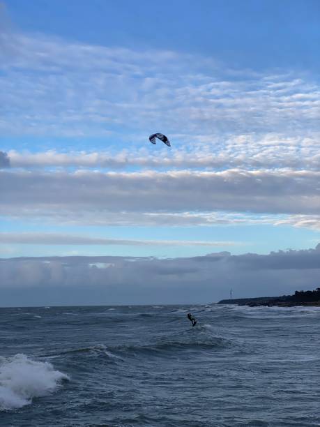 istock Kitesurfer soaring over ocean waves under a vibrant sky. 2187303317