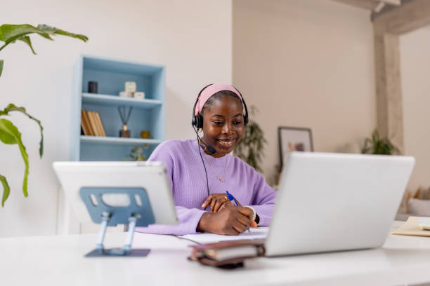 istock Woman in headset working on laptop at home office 2187304433
