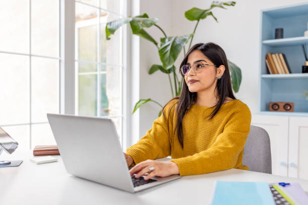 istock Woman in yellow sweater working in bright office space 2187304957