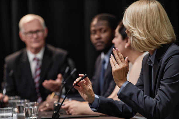 istock Female Politician Asking Speaker Question during Presentation while Sitting in Line with Colleagues 2187306049