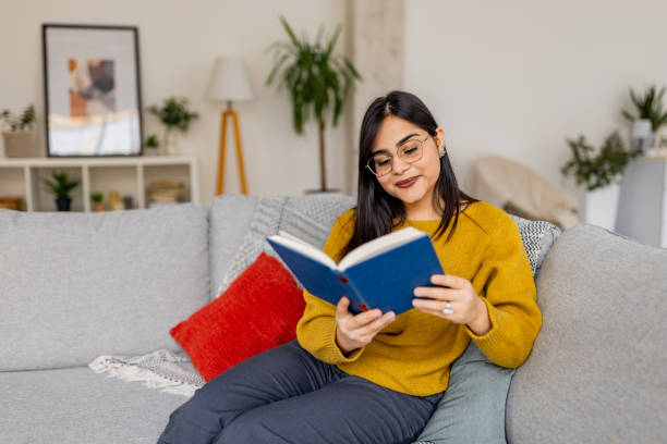 istock Woman with glasses deeply engaged in book reading 2187306420