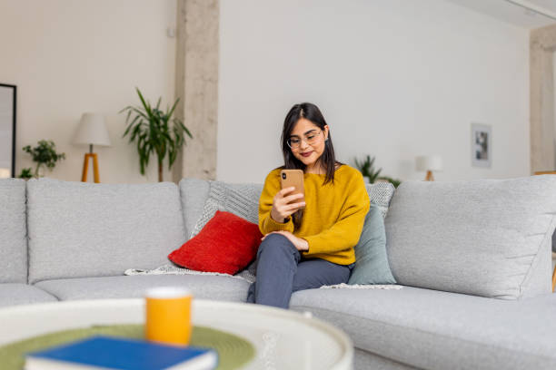 istock Woman with smartphone in serene modern living area 2187306529