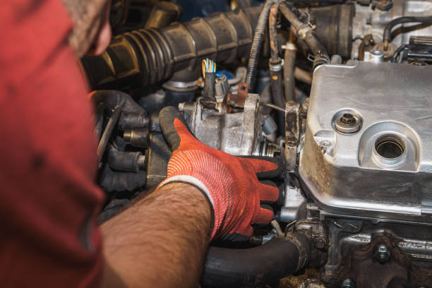 istock The mechanic is reassembling the distributor in the auto service. Replacing a rubber gasket. Valve cover, air filter intake pipe, ignition coil. Car engine repairing. 2187307250