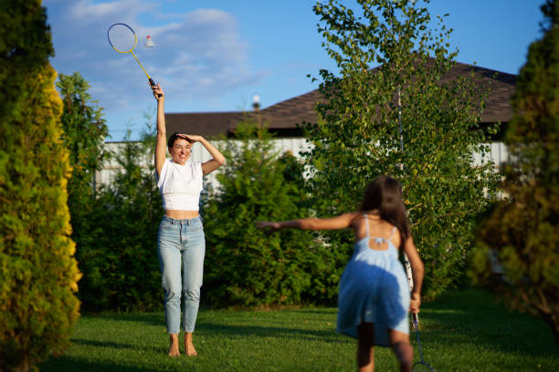 istock Women playing badminton in a sunny backyard during late afternoon 2187308310