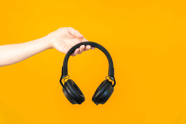 istock Close up woman's hand holding large black wireless headphones. 2187308909
