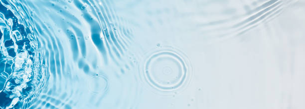 istock abstract transparent blue water wave from above, rippled texture with drop circle and color gradient, concept banner with copy space for beauty spa, cosmetics or travel background 2187312208
