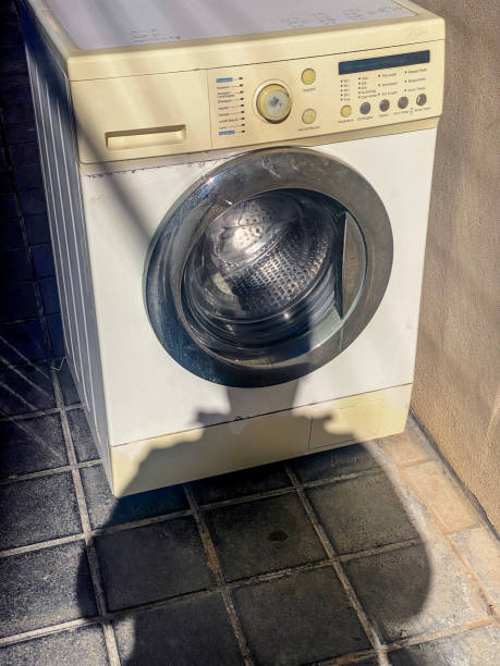 istock Shadow of man next to abandoned washing machine 2187313398