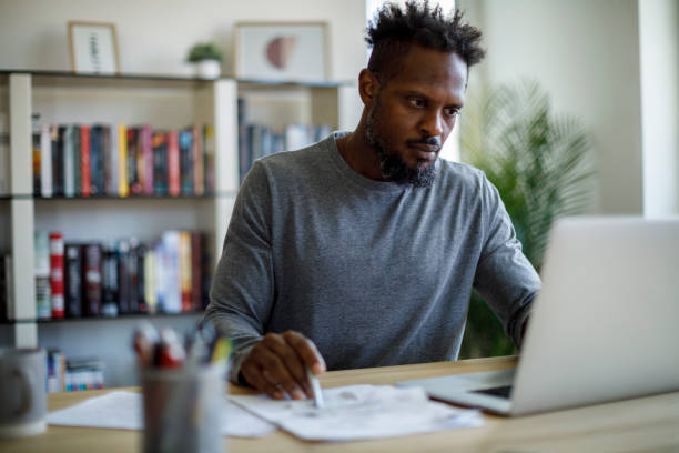 istock Man organizing documents for tax preparation at home 2187314355