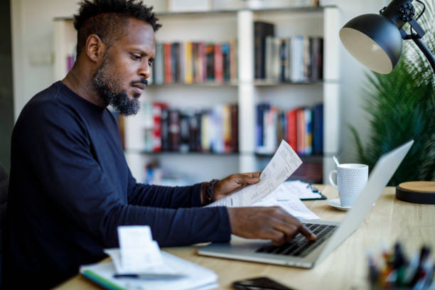 istock Man organizing documents for tax preparation at home 2187314362
