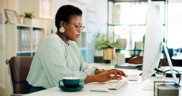 istock Black woman, office and computer with typing and blog post for digital journalist at creative agency. Working, employee and desk with tech, planning and company website update with research of staff 2187314452