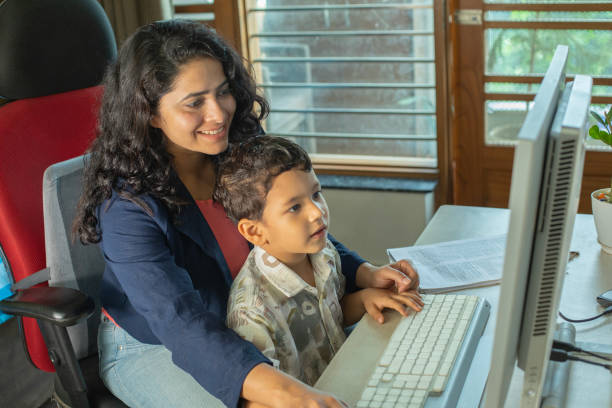 istock Mother and son using desktop PC on desk in home office 2187318410