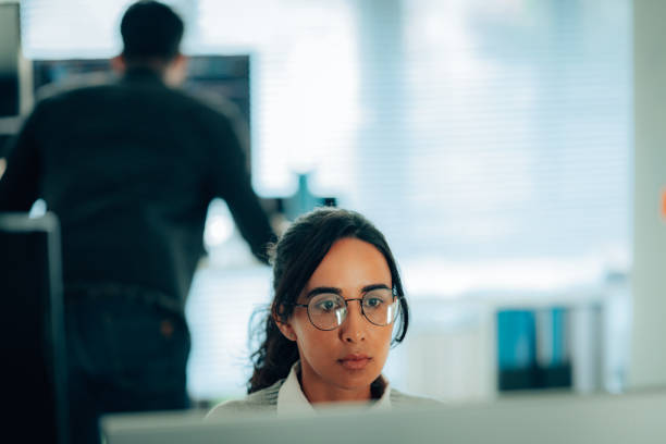 istock A woman programmer wearing glasses, focused on her tasks in a modern and professional office setting, highlighting determination and innovation. 2187318631