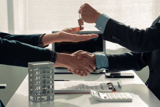 istock A real estate agent is explaining the terms of a home purchase contract. and the customer is legally signing the contract, close-up image 2187324687