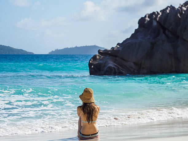 istock Cute woman sitting on stunning white sand beach 2187325662