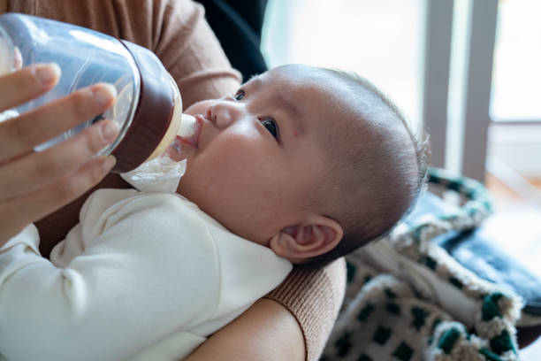 istock Baby drinking milk in arms 2187326712