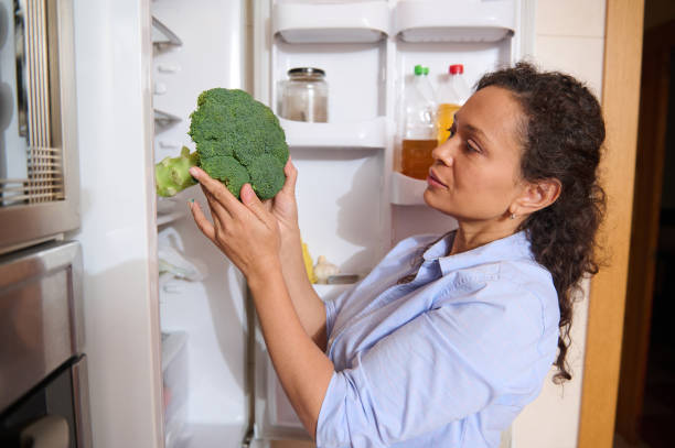 istock Woman inspecting fresh broccoli from the refrigerator 2187327746