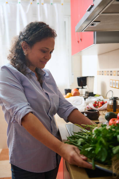 istock Woman preparing fresh vegetables in a modern kitchen 2187327749