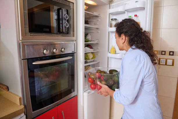 istock Woman organizing fresh produce in a modern kitchen refrigerator 2187328325