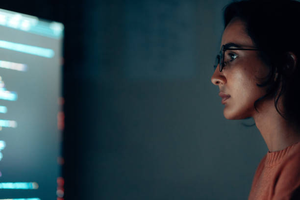 istock Latin Female IT Professional Concentrating on Software Development in a Dark Workspace 2187329495
