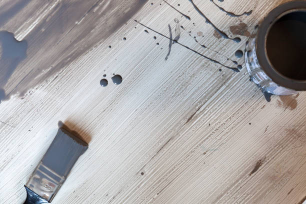 Opened grey paint and brush on top of the old table. Renovation DIY. Close up view. Flat Lay