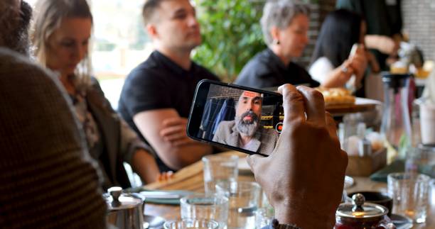 istock Blogger recording feedback about event using smartphone, sitting at table in casual atmosphere. Concept content creation, storytelling, sharing opinions for social media audience. Blogger Concept 2187331362