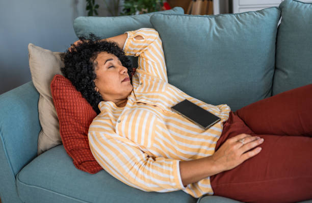 istock Tired woman taking a nap on the sofa 2187331448