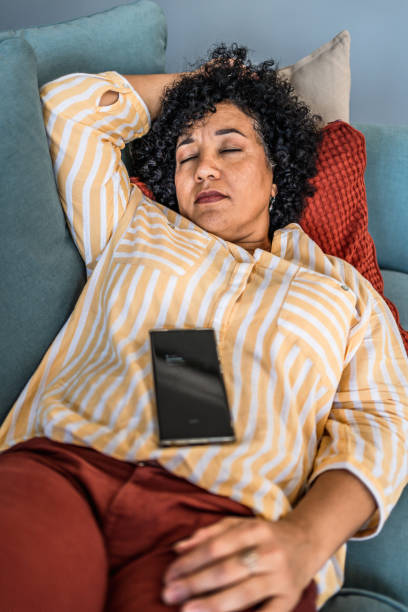 istock Tired woman taking a nap on the sofa 2187332084