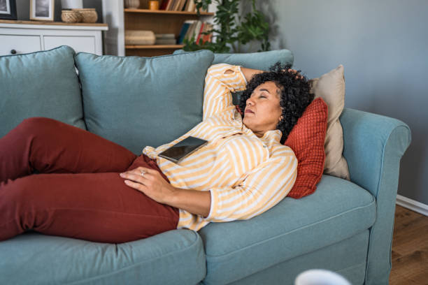 istock Tired woman taking a nap on the sofa 2187332105