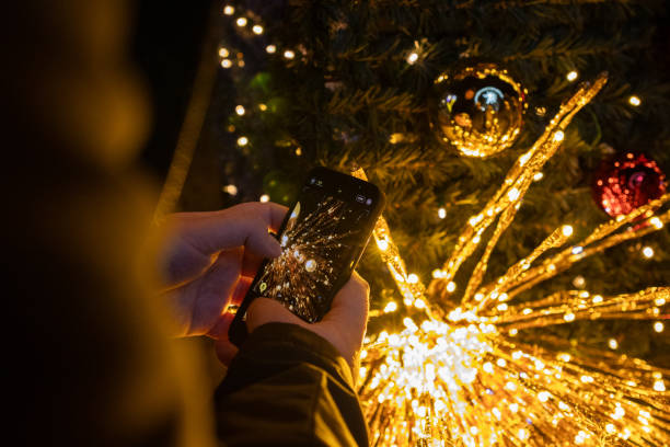 istock capturing christmas lights with a smartphone, festive decorations, illuminated tree, golden glow, holiday spirit, photography moment, night shot 2187333562