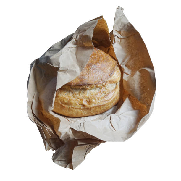 Loaf of bread with the brown paper it was wrapped in. Isolated on white. This is a traditional Ukrainian sour-dough bread, known as Palyanytsya.