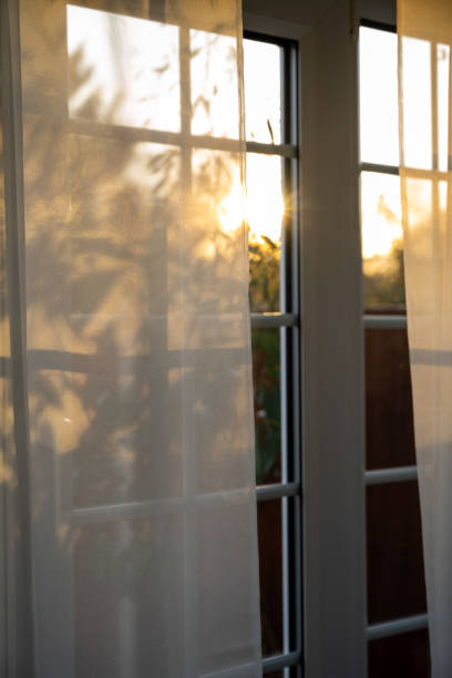 istock Sunset through the transparent curtains at the window, autumn time 2187339057