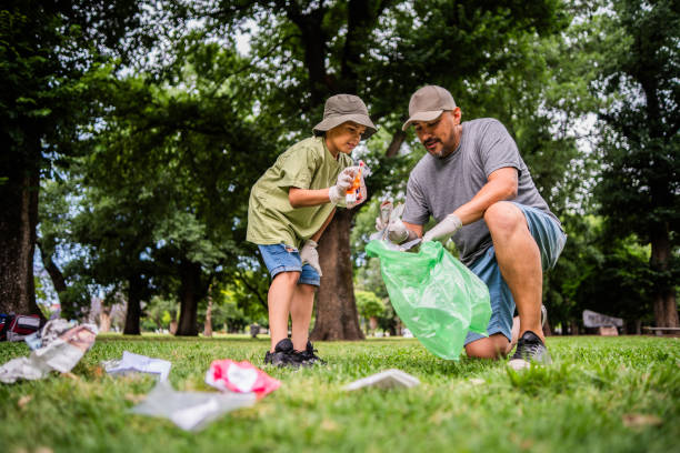 istock Father and son collecting trash in public park 2187339296