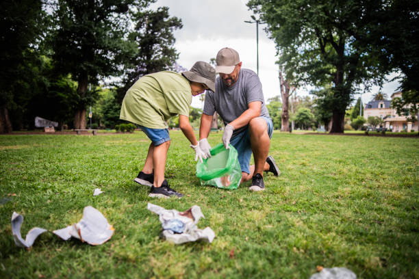 istock Father and son collecting trash in public park 2187339320