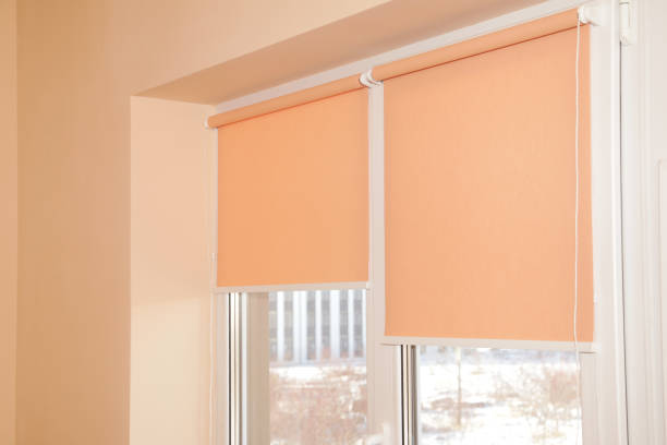 istock Window Blinds Shades Indoor. Roller Blinds Peach color, Modern Fabric Shutters in room 2187339327