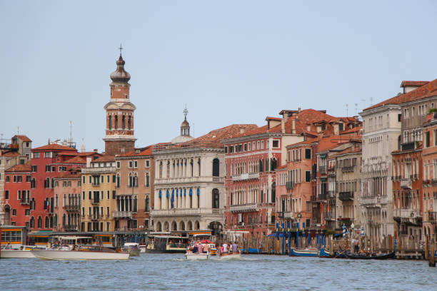 Side view of Venice cityscape with Church of San Bartolomeo di Rialto. City street view from sailing tourboat on Grand Canal in a sunny summer day. Copy space. Travel in Italy theme.