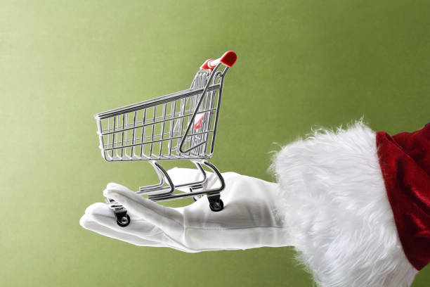 istock Santa's hand holding empty shopping cart isolated on green background 2187339518