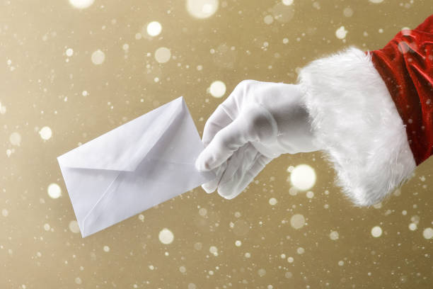 istock Santa Claus hand holding white envelope on snowy brown background 2187339523